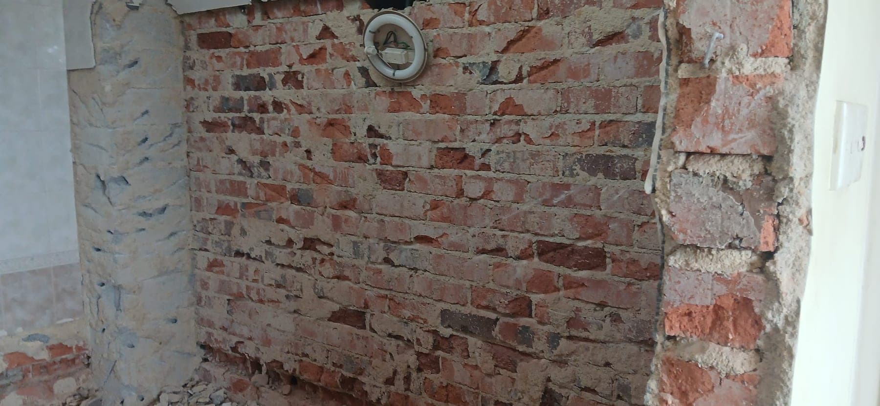 Exposed brick wall after hacking works for JBC demo works scope review