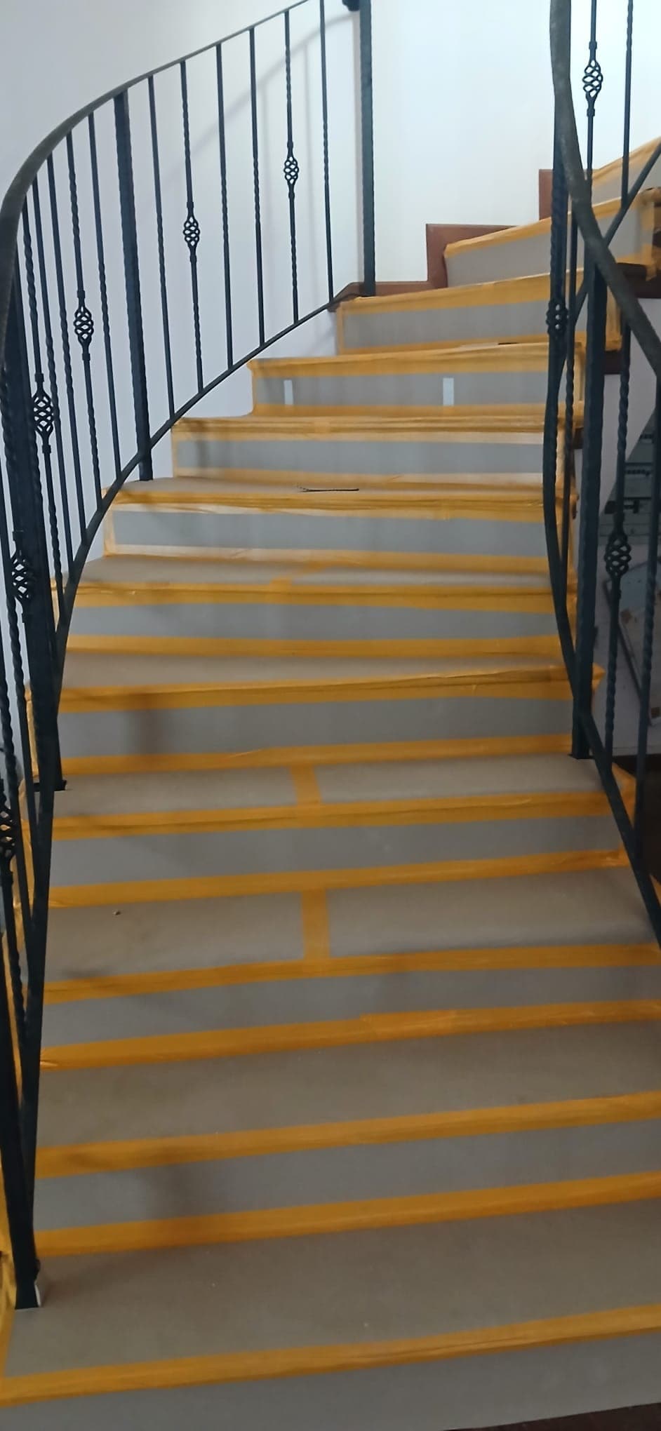 Staircase protected with floor covering and yellow tape before site works