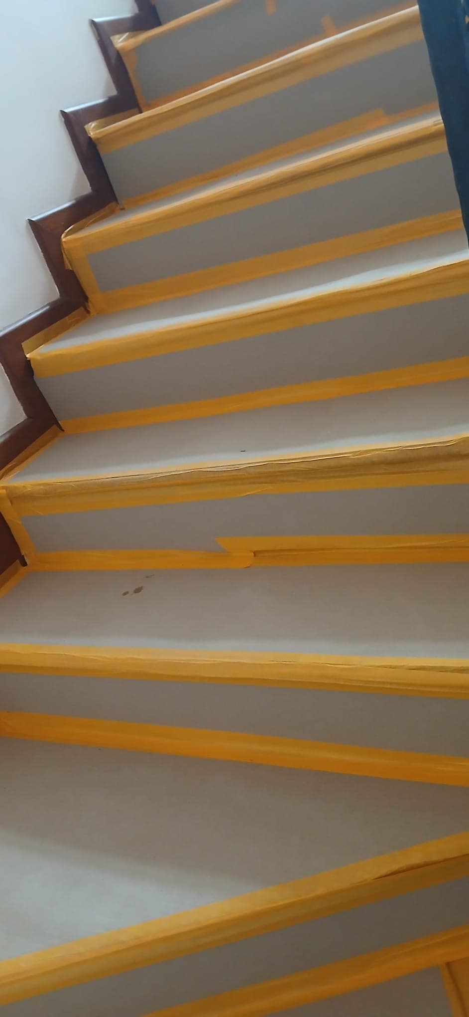 Close-up of protected stair treads with taped covering before works